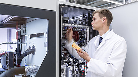 Employee checking Voltage of the Components inside a Test System
